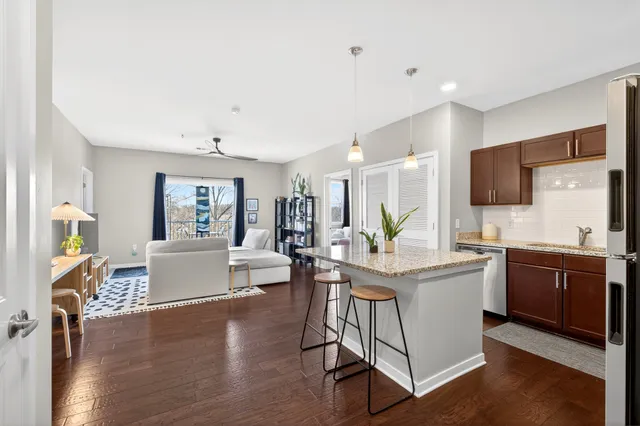 a living room with furniture a flat screen tv and kitchen view
