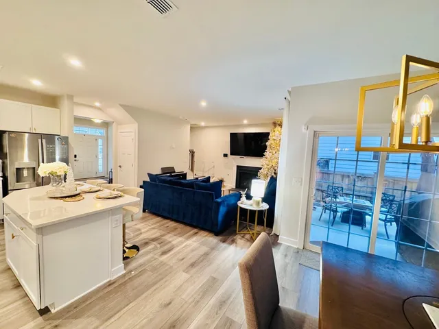 a living room with stainless steel appliances kitchen island granite countertop furniture and a wooden floor