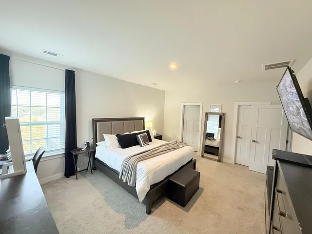 a bedroom with a bed a couch and dresser