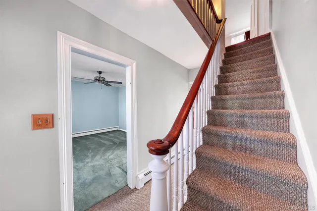 a view of a livingroom with a chandelier fan and a window