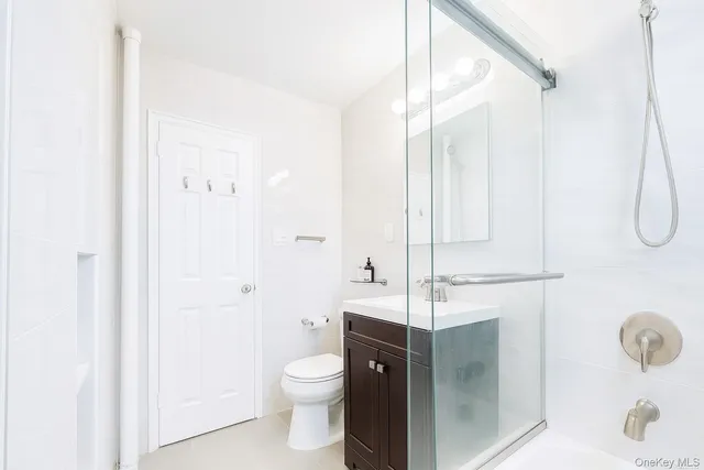 a bathroom with a granite countertop sink a toilet and shower