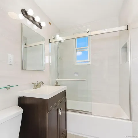 a bathroom with a sink mirror toilet and bathtub