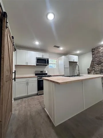a kitchen with granite countertop white cabinets and stainless steel appliances
