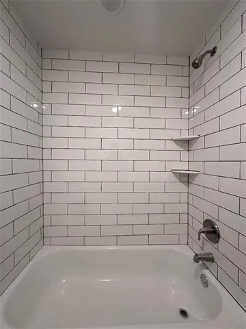 an empty room with windows and ceiling fan