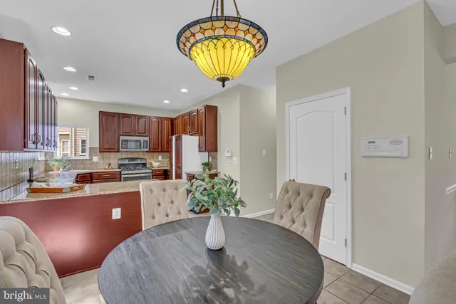 a kitchen with stainless steel appliances granite countertop a refrigerator a stove a sink dishwasher and white cabinets with wooden floor