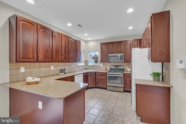 a kitchen with granite countertop stainless steel appliances and wooden cabinets