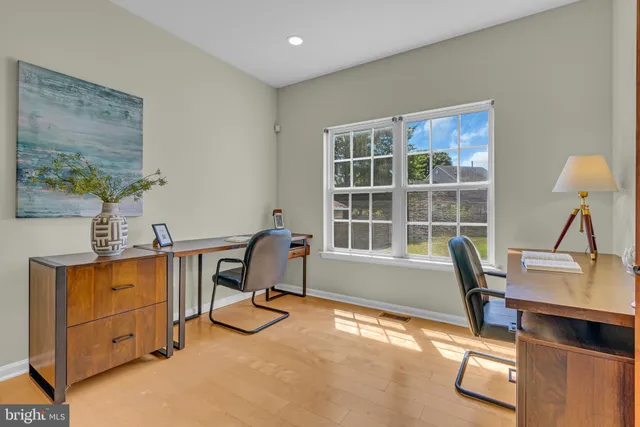 a view of a workspace with furniture and a window