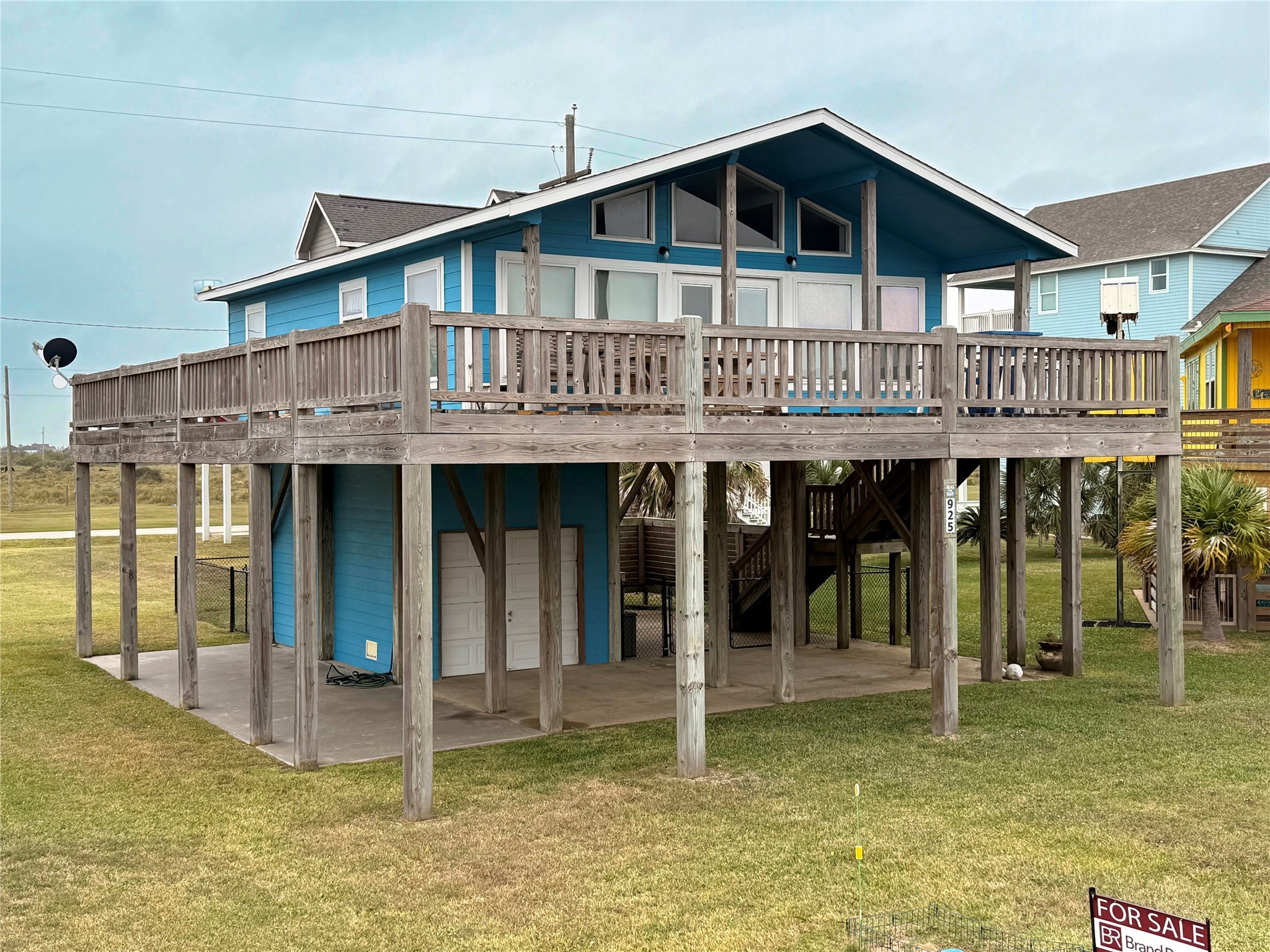 925 Honeysuckle Crystal Beach, TX 77650 - Photo 3 of 20 a view of a house with wooden deck and floor to ceiling window