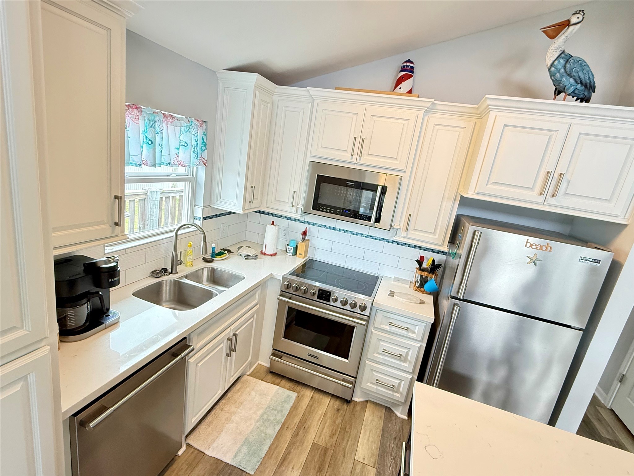 925 Honeysuckle Crystal Beach, TX 77650 - Photo 8 of 20 a kitchen with stainless steel appliances a stove a sink and a refrigerator