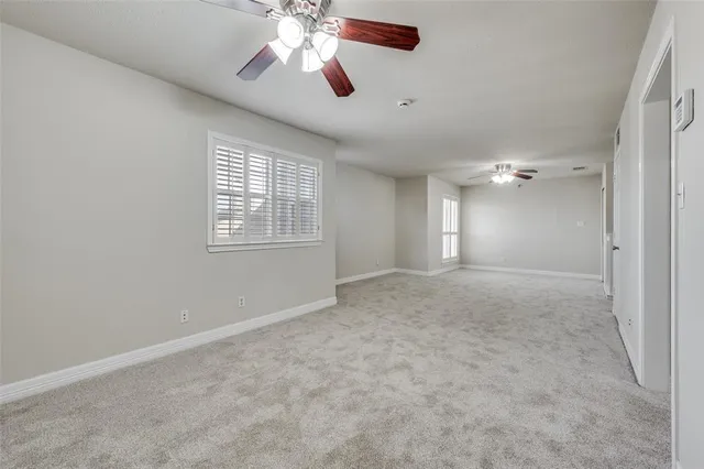 en empty room with windows and fan