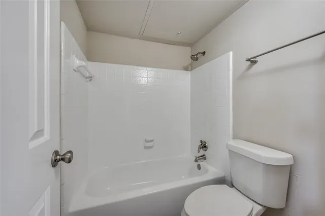 a white toilet sitting next to a bath tub