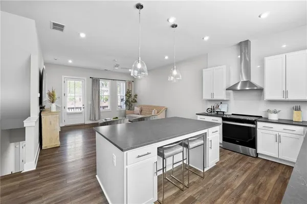 a kitchen with stainless steel appliances granite countertop a sink stove and wooden floor