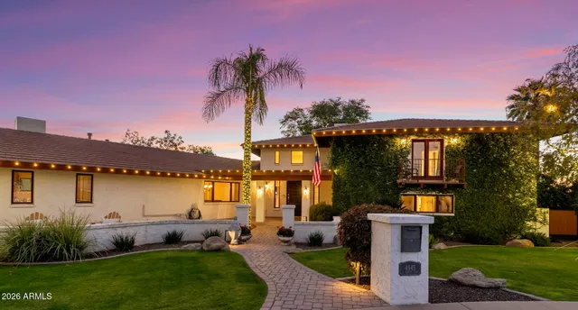 a front view of a house with a garden and a tree