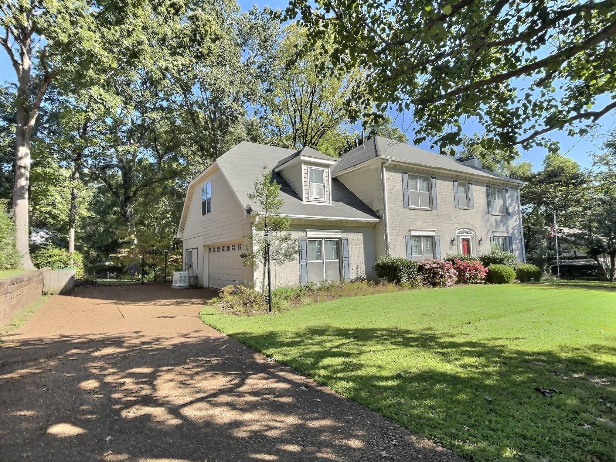 8222 Dogwood Road Germantown, TN 38139 - Photo 2 of 40 a view of a white house that has a tree in front of it