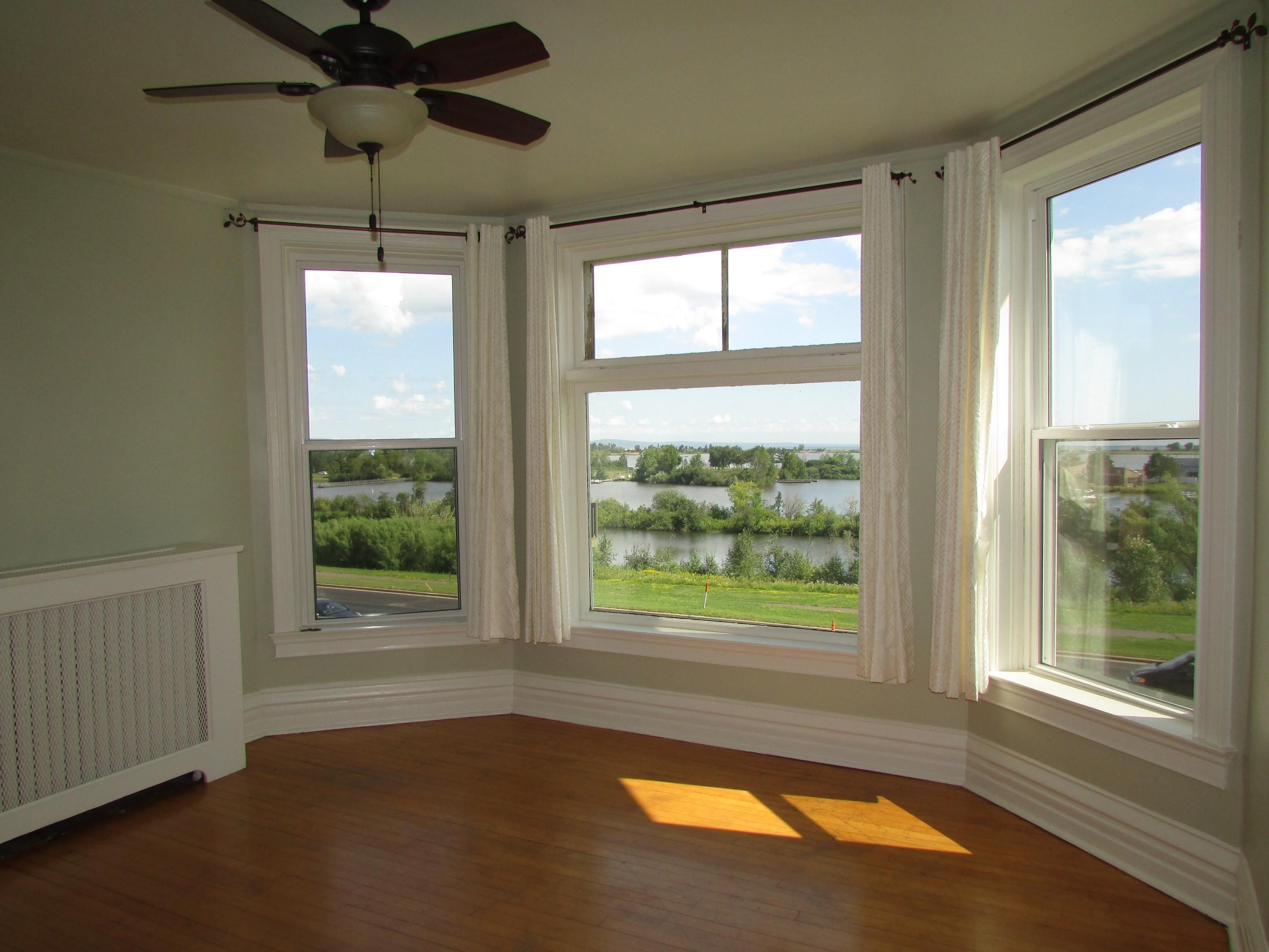 1212 East 2nd Street Superior, WI 54880 - Photo 13 of 19 Unfurnished sunroom featuring a water view, ceiling fan, and radiator heating unit