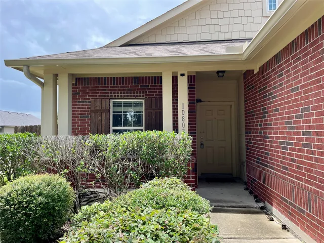 a view of brick house with potted plants