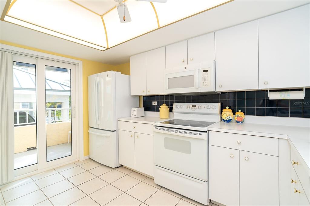 2424 Placida Road, Unit C101 Englewood, FL 34224 - Photo 15 of 65 a kitchen with granite countertop white cabinets and white appliances