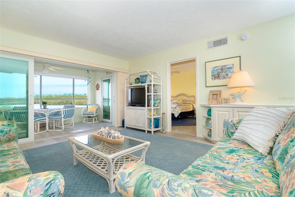 2424 Placida Road, Unit C101 Englewood, FL 34224 - Photo 20 of 65 a living room with furniture a fireplace and a floor to ceiling window