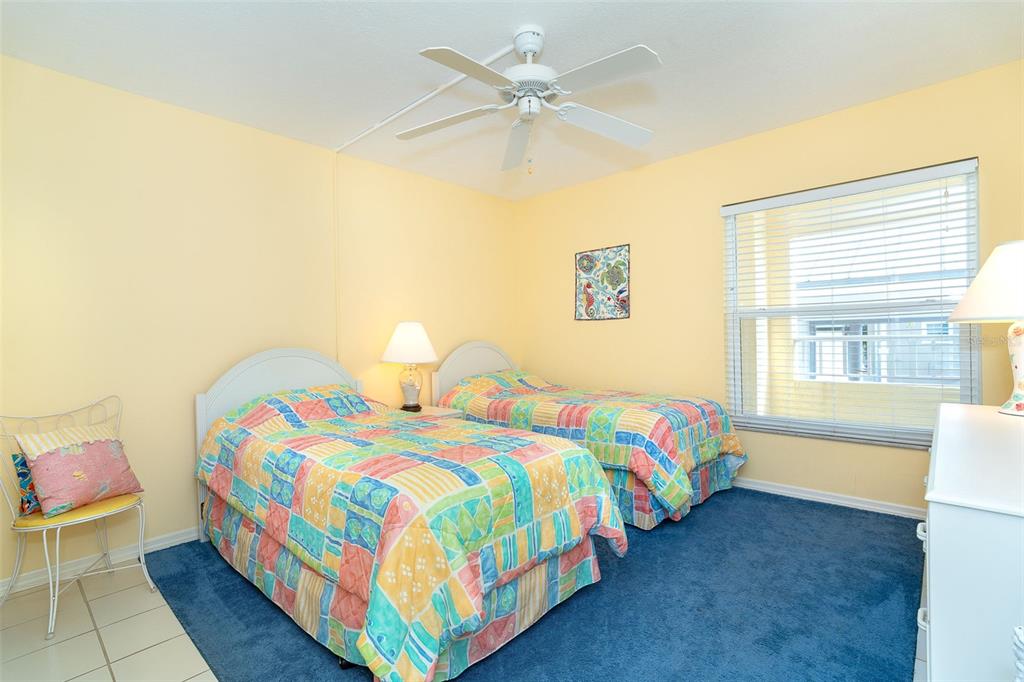 2424 Placida Road, Unit C101 Englewood, FL 34224 - Photo 34 of 65 a bedroom with two beds and a chandelier