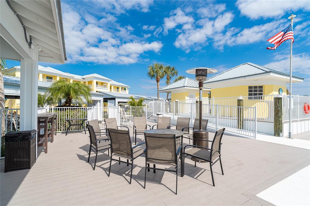 2424 Placida Road, Unit C101 Englewood, FL 34224 - Photo 51 of 65 a view of a patio with a dining table and chairs with wooden floor