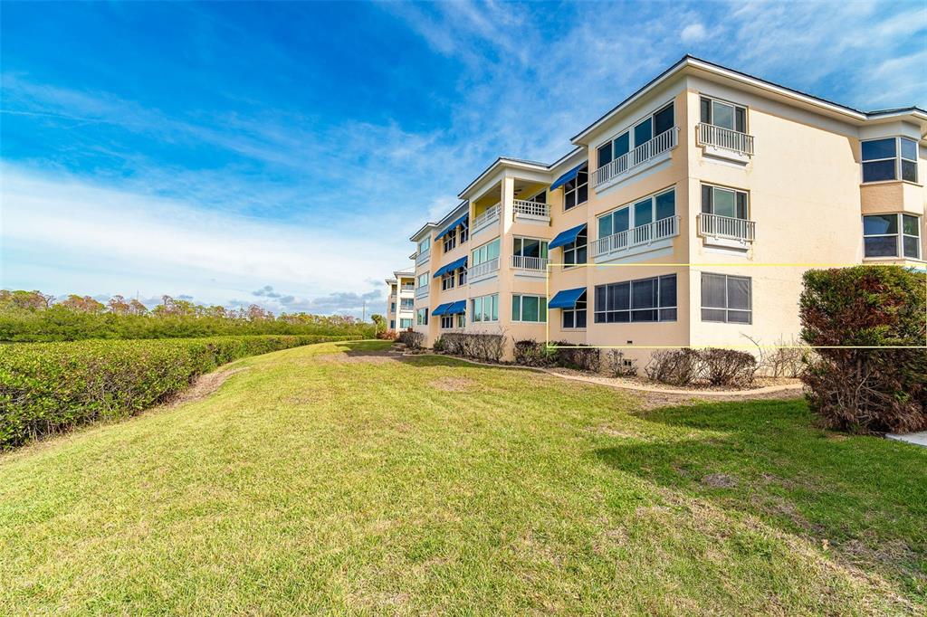 2424 Placida Road, Unit C101 Englewood, FL 34224 - Photo 6 of 65 a front view of a house with swimming pool next to a yard