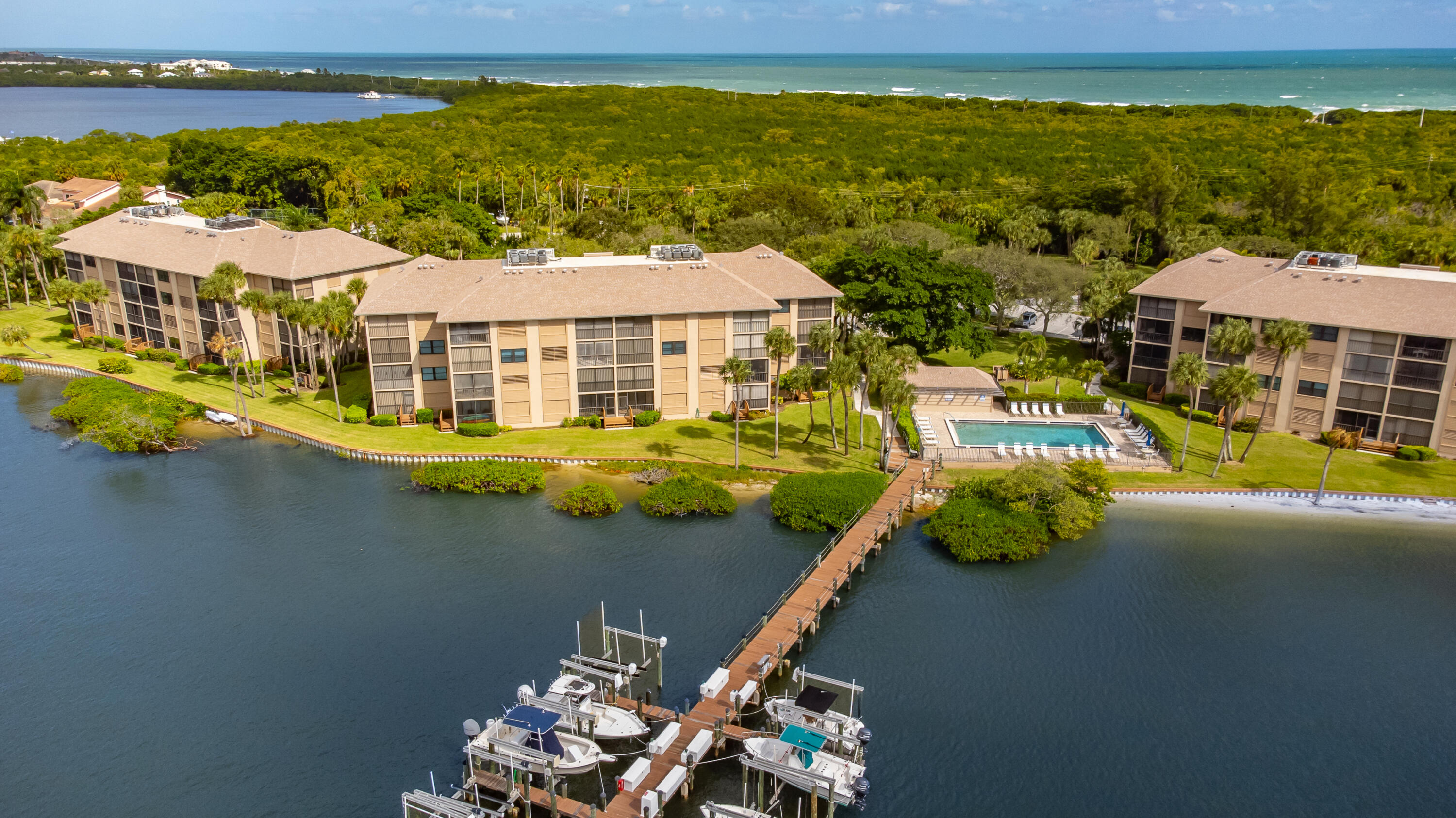 4440 Northeast Sandpebble Trace, Unit 104 Stuart, FL 34996 - Photo 19 of 33 a view of residential houses with outdoor space and lakeside