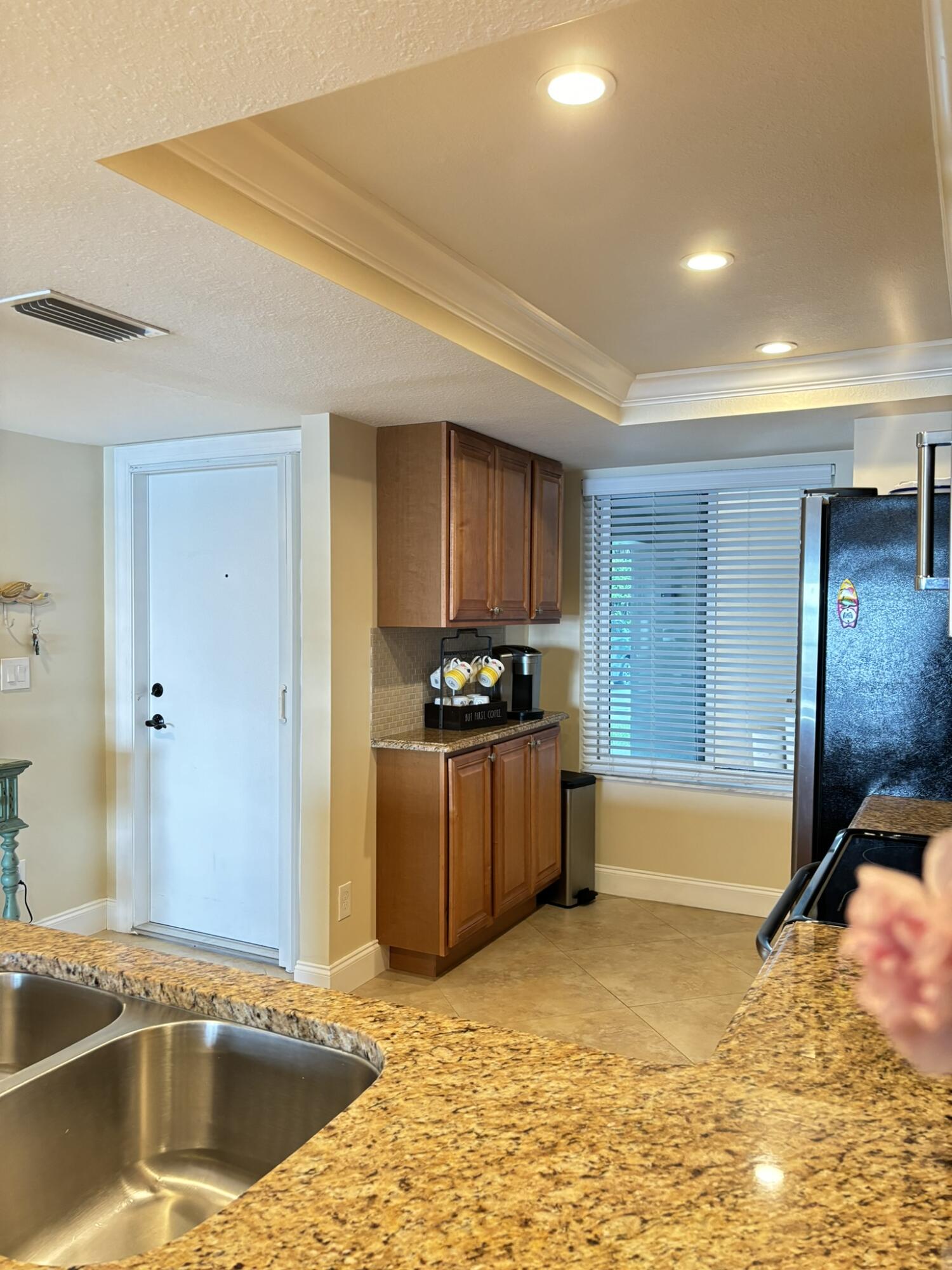 4440 Northeast Sandpebble Trace, Unit 104 Stuart, FL 34996 - Photo 21 of 33 a kitchen with stainless steel appliances granite countertop a sink and a stove
