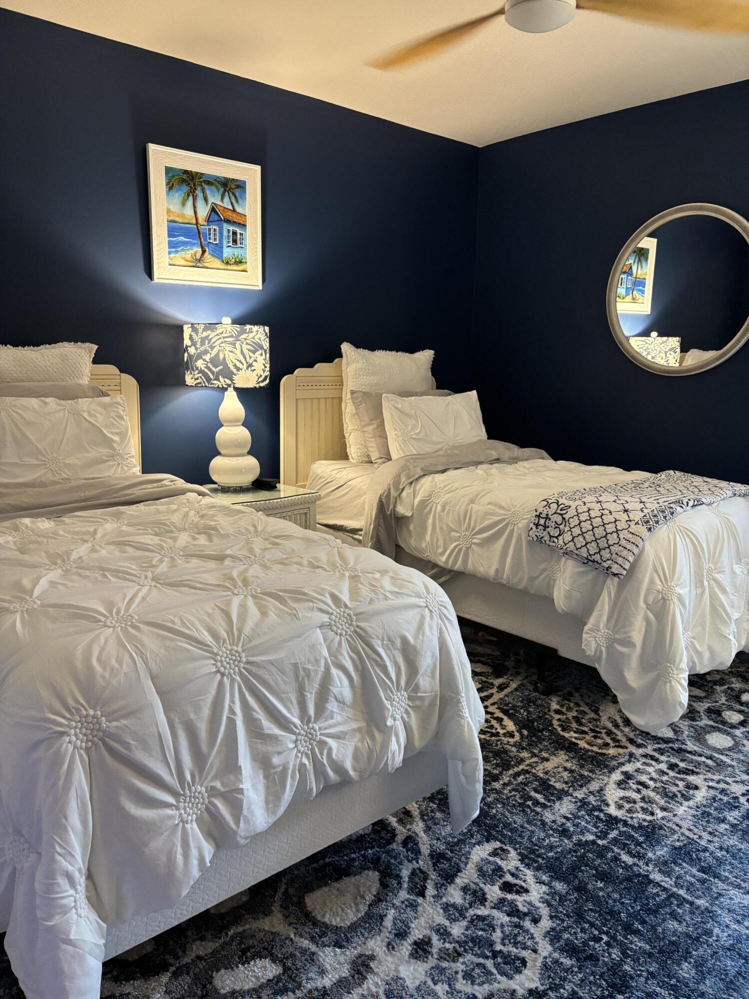 4440 Northeast Sandpebble Trace, Unit 104 Stuart, FL 34996 - Photo 4 of 33 a bedroom with a bed and a lamp