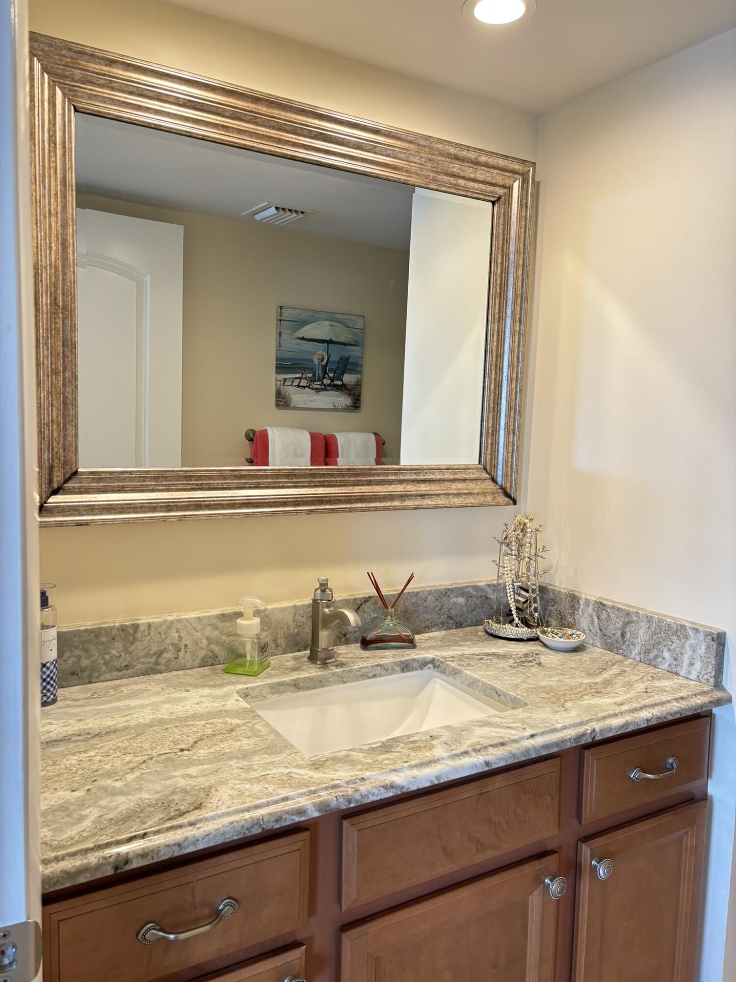 4440 Northeast Sandpebble Trace, Unit 104 Stuart, FL 34996 - Photo 7 of 33 a bathroom with a granite countertop sink and a mirror