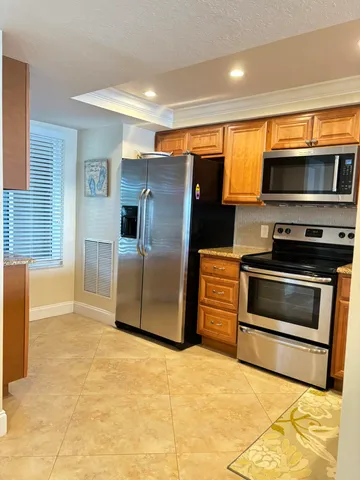 a kitchen with stainless steel appliances granite countertop a refrigerator and a stove