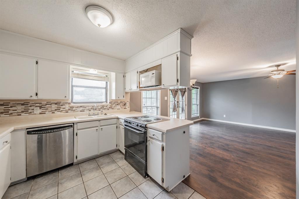 245 Gordon Drive Azle, TX 76020 - Photo 11 of 38 a kitchen with granite countertop cabinets stainless steel appliances and a sink