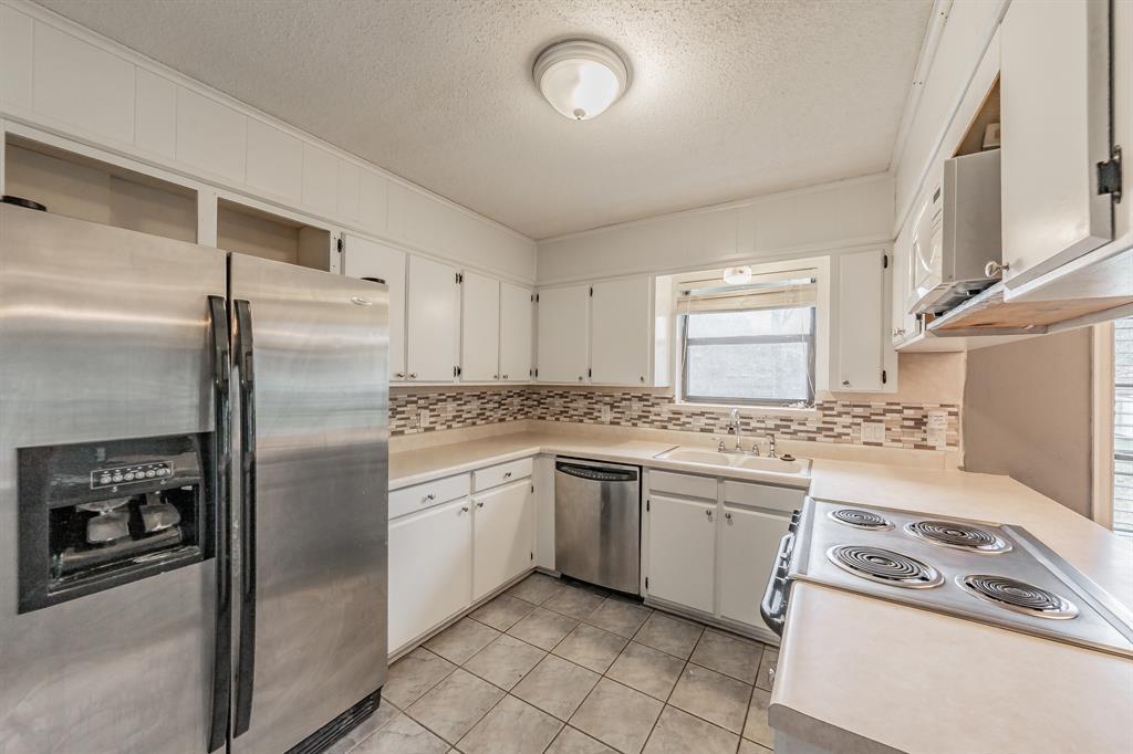 245 Gordon Drive Azle, TX 76020 - Photo 12 of 38 a kitchen with a stove sink and refrigerator