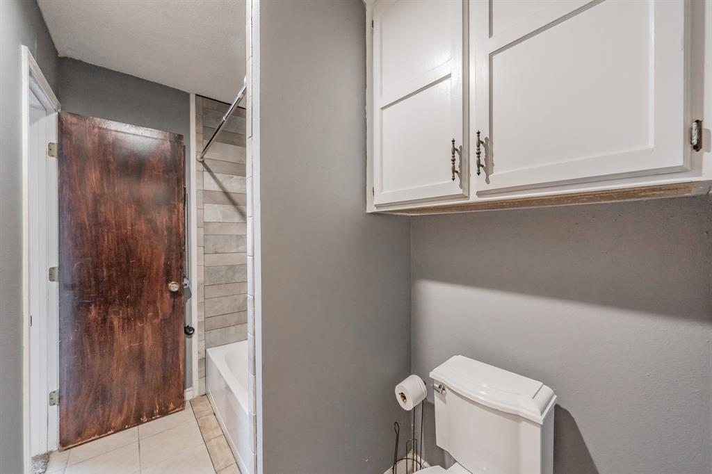 245 Gordon Drive Azle, TX 76020 - Photo 20 of 38 a bathroom with a window and a toilet