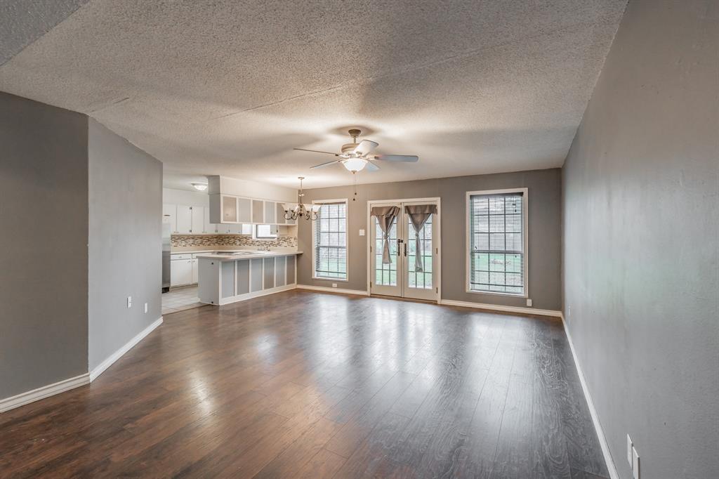 245 Gordon Drive Azle, TX 76020 - Photo 4 of 38 a view of an empty room with wooden floor and a window