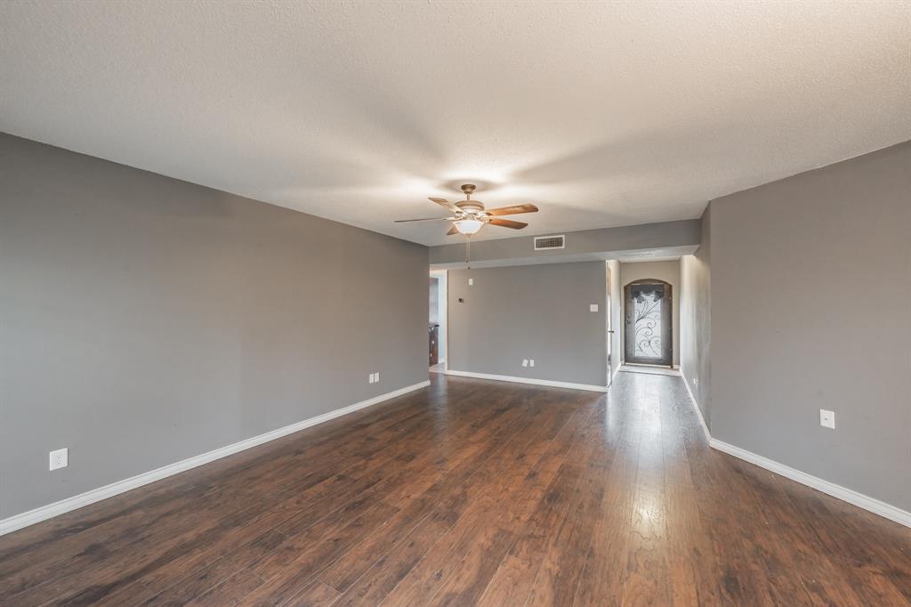 245 Gordon Drive Azle, TX 76020 - Photo 7 of 38 a view of an empty room with wooden floor and a window