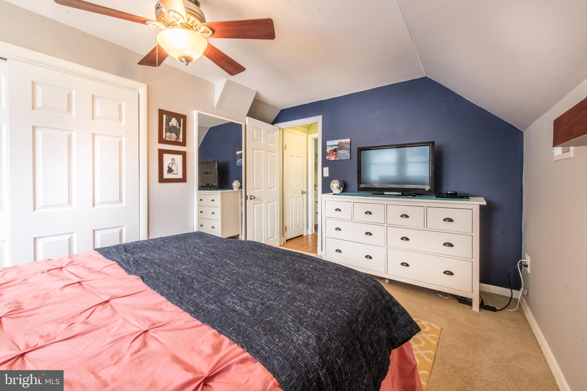 1346 Sudvale Road Baltimore, MD 21208 - Photo 19 of 30 a spacious bedroom with a bed a flat screen tv and a dresser