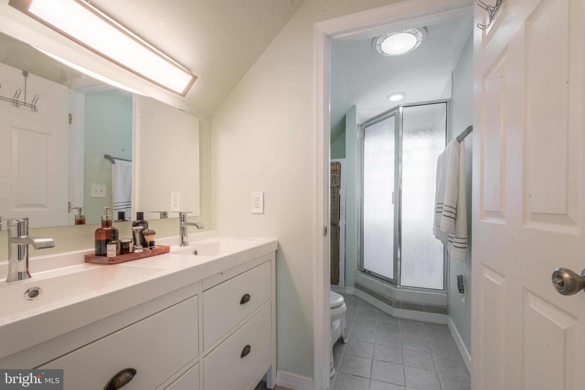 1346 Sudvale Road Baltimore, MD 21208 - Photo 20 of 30 a bathroom with a double vanity sink a mirror and a bathtub