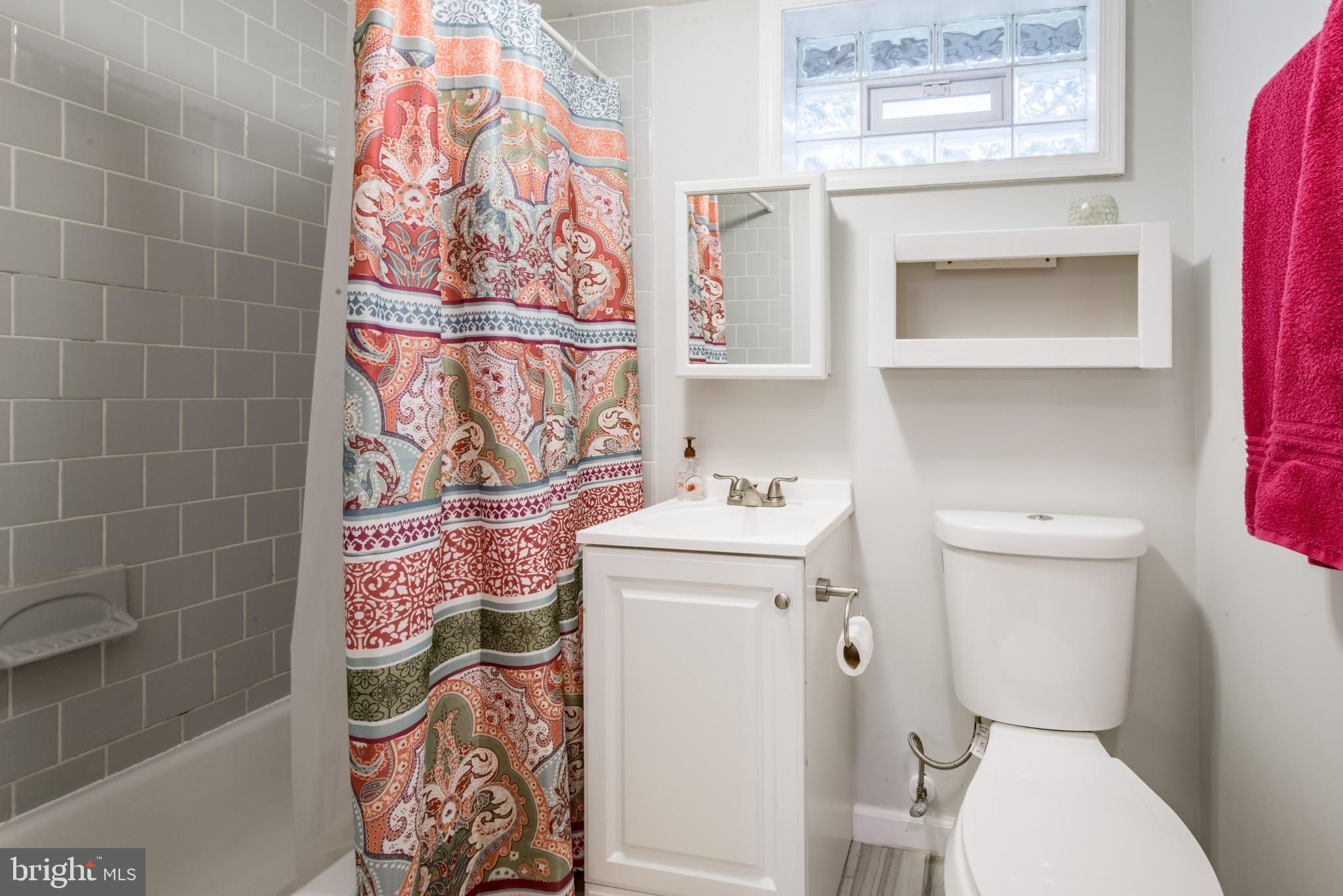 1346 Sudvale Road Baltimore, MD 21208 - Photo 25 of 30 a bathroom with a toilet and a shower curtain