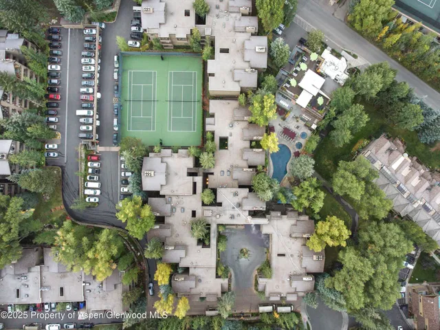 an aerial view of a residential apartment building with a yard and garden space