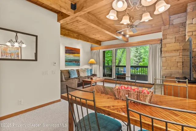 a view of a dining room with furniture large windows and a chandelier