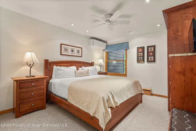 a bedroom with a bed and lamp on dresser