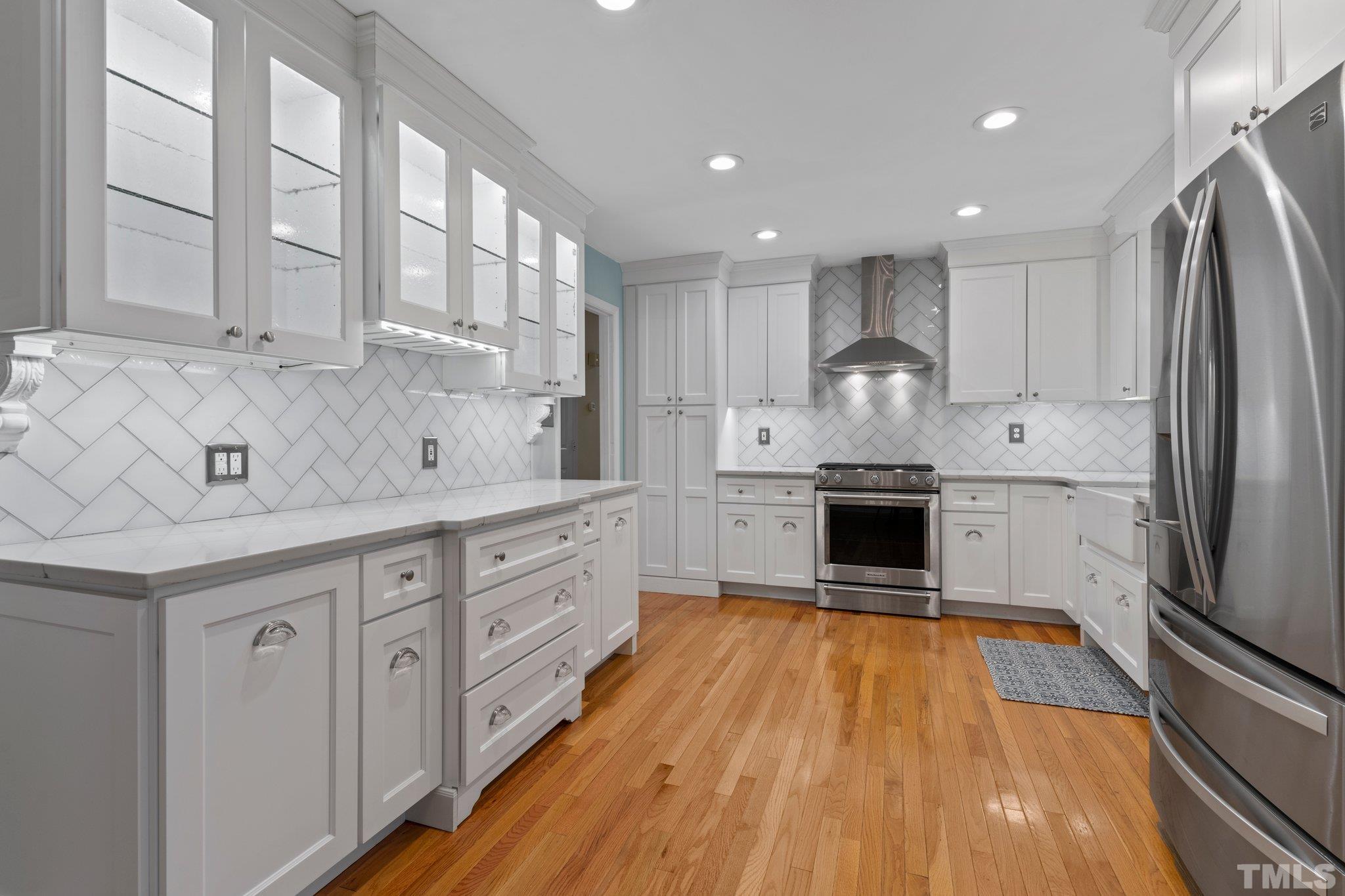 5101 Raintree Road Durham, NC 27712 - Photo 6 of 30 a open kitchen with stainless steel appliances granite countertop a sink dishwasher a refrigerator and white cabinets with wooden floor