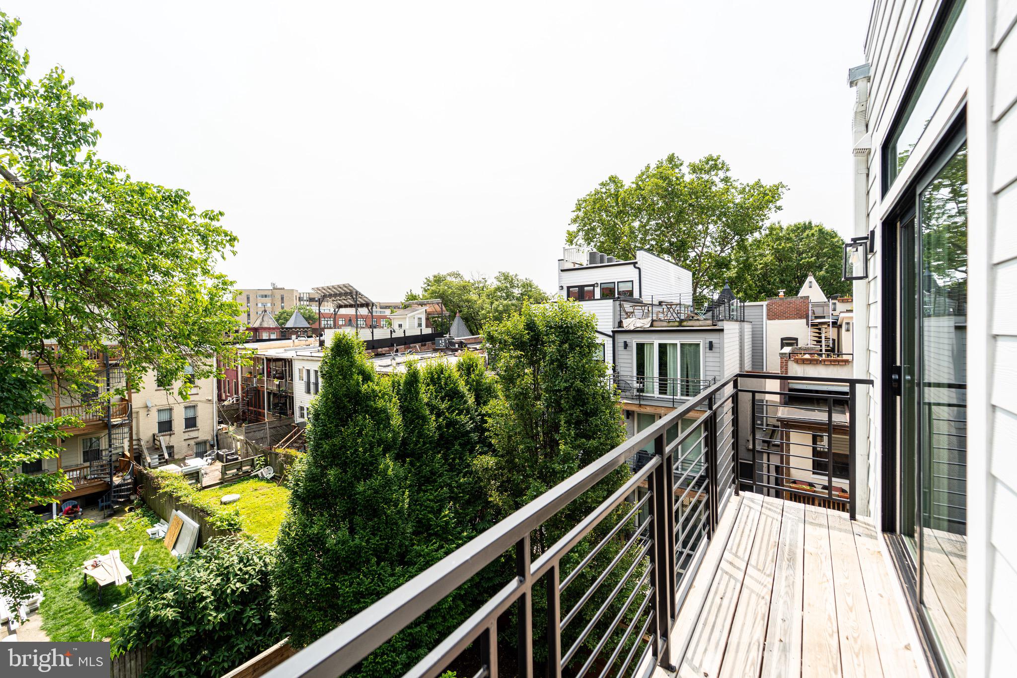 2517 Ontario Road Northwest, Unit PH8 Washington, DC 20009 - Photo 17 of 41 a balcony with tall trees in front of it