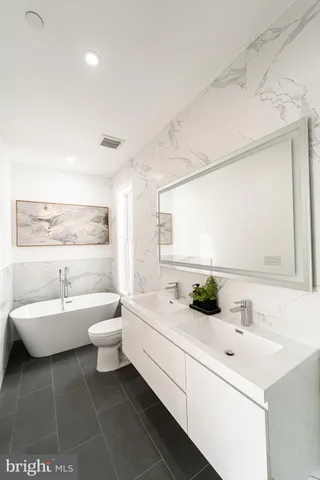 a bathroom with a double vanity sink toilet and a mirror