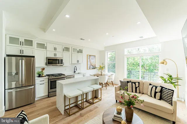 a living room with furniture and a refrigerator