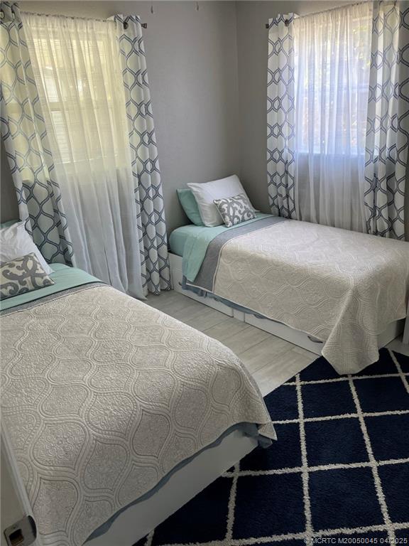 2340 Northeast Rustic Way Jensen Beach, FL 34957 - Photo 11 of 19 a bedroom with a bed and a window