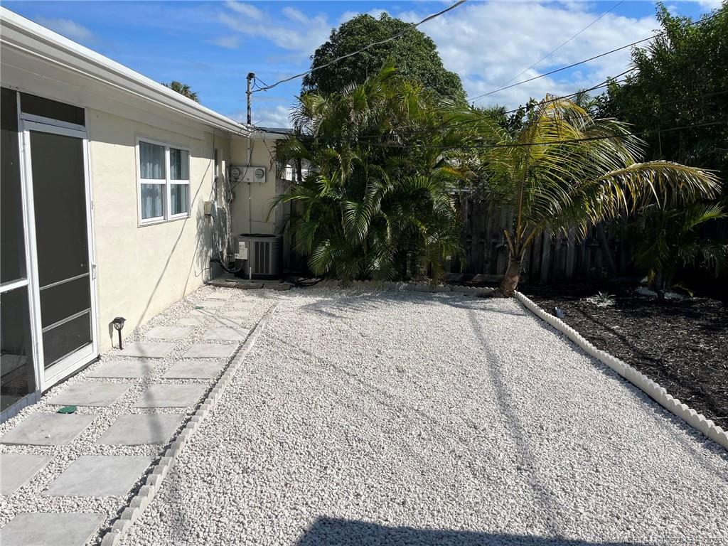 2340 Northeast Rustic Way Jensen Beach, FL 34957 - Photo 16 of 19 a view of backyard with potted plants and palm trees