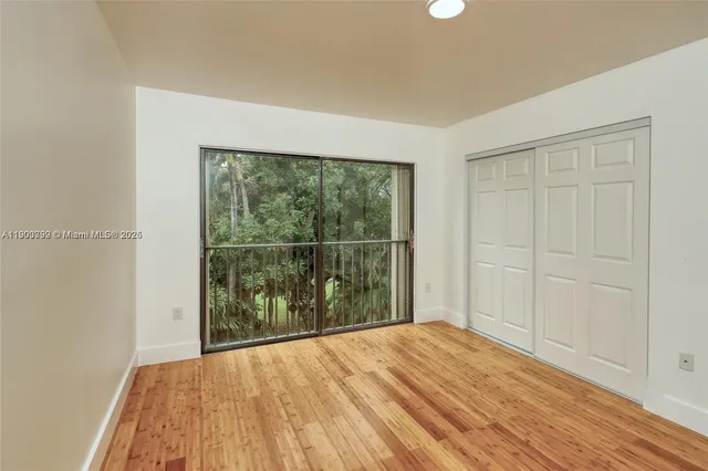 a view of a bedroom with wooden floor and windows