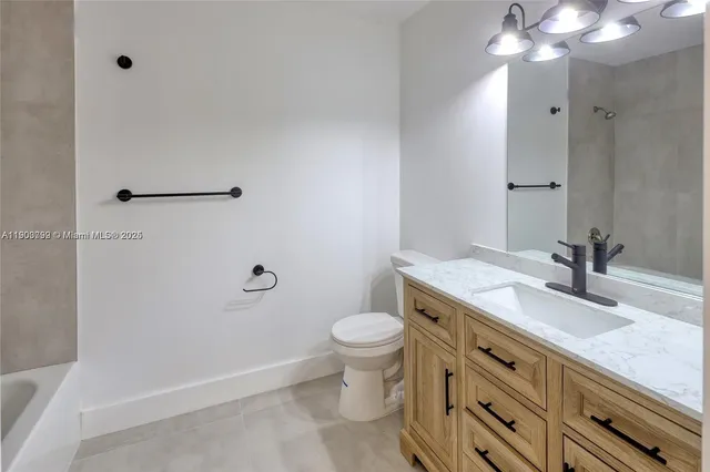 a bathroom with a granite countertop sink toilet and a mirror
