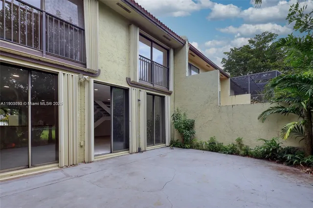 a view of a house with a yard and potted plants